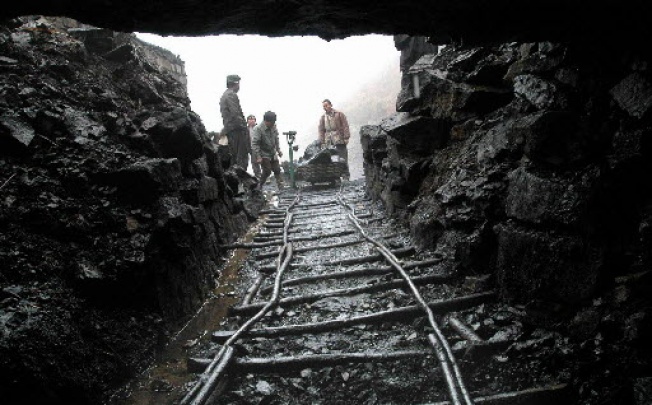 A file photo of workers weighing bundles of coal at the entrance of a rural coalpits in Pingba, southwest China's Guizhou Province. Photo: EPA