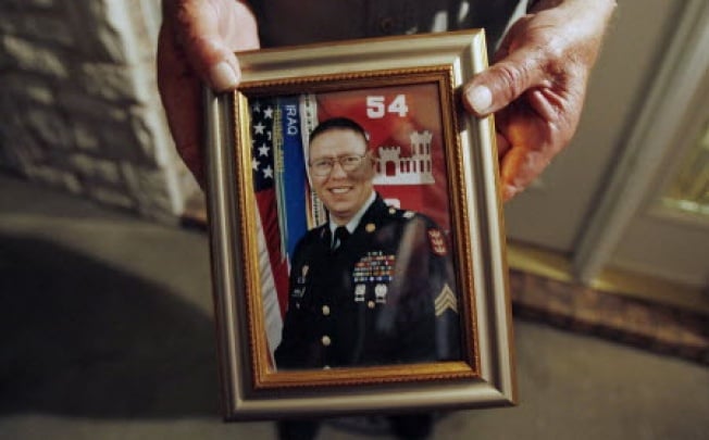 Wilburn Russell, 73, displays a portrait of his son, Sergeant John M. Russell. Photo: Reuters