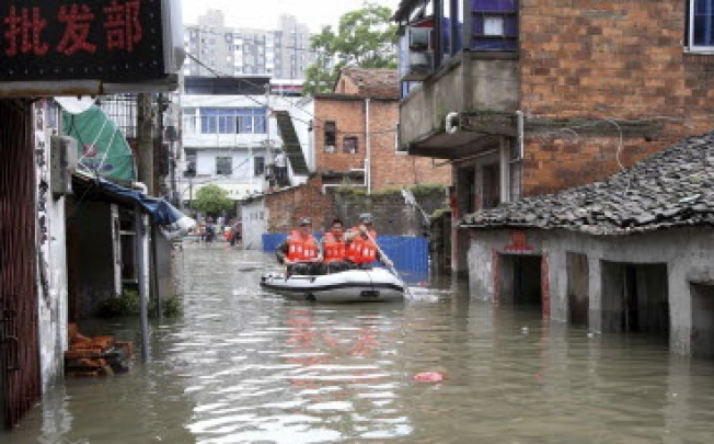 Rescuers paddle a boat to transport residents on a flooded street after a heavy rainstorm hit Nanchang, Jiangxi province this week. Photo: Reuters