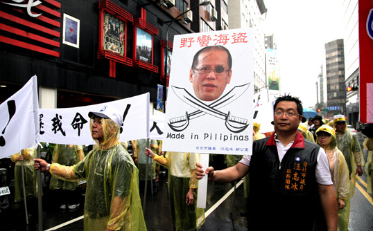 Hundreds of Taiwan fishermen, holding a portrait of Philippine President Benigno Aquino, march to the Philippine trade office in Tapei in protest last week. Photo: EPA