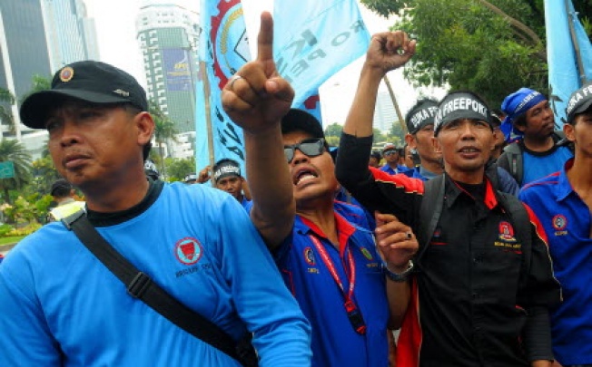 Indonesian workers shout slogans during a rally in front of the Ministry of Energy and Mineral Resources in Jakarta, Indonesia. Photo: Xinhua
