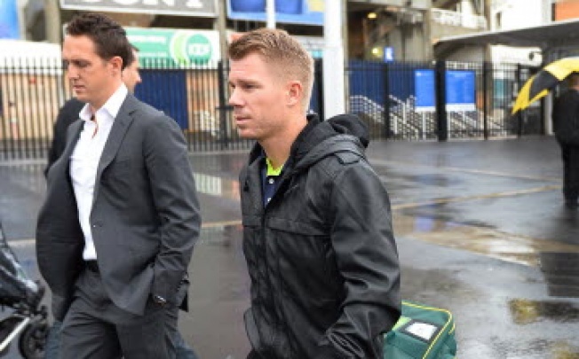  Australia's cricketer David Warner (centre) leaves a press conference with his manager Tony Connolly (left). Photo: AFP