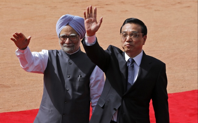 Chinese Premier Li Keqiang (right) and India's Prime Minister Manmohan Singh wave towards the media in New Delhi. Photo: Reuters