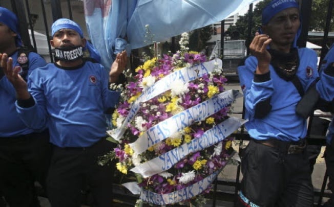 Members of Indonesian Workers Union (SPSI) pray during a solidarity rally for the victims of the collapsed mine at a Freeport Indonesia's mining area in Papua province, outside the Ministry of Energy And Natural Resources in Jakarta, Indonesia. Photo: AP