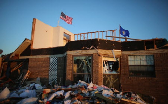 An American flag flies over a home damaged after a tornado hit on June 1, 2013 in El Reno, Oklahoma. The tornado ripped through the area last night killing at least nine people, injuring many others and destroying homes and buildings. Photo: AFP