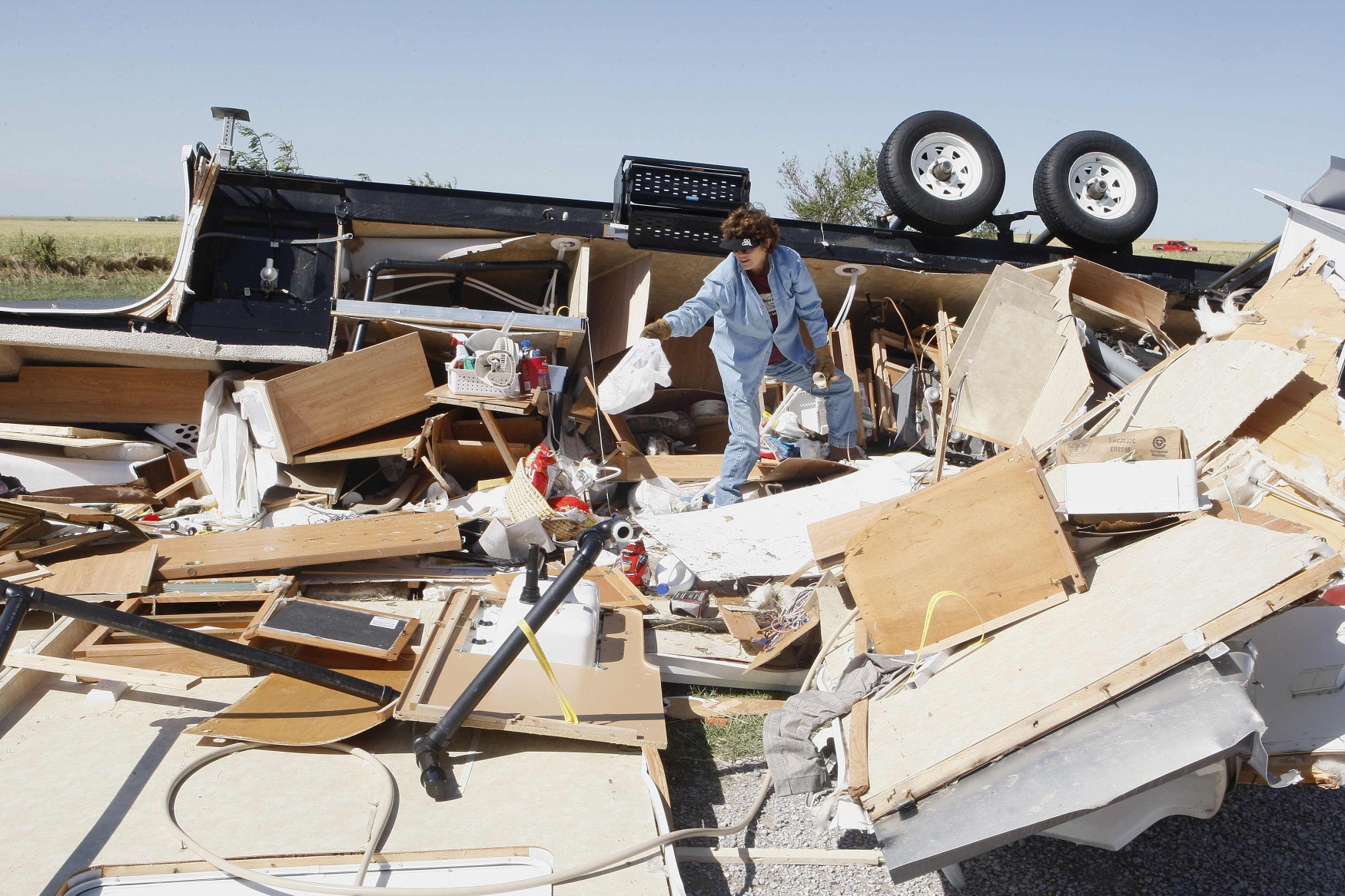 A woman collects her belongings which were destroyed by the tornado in El Reno in Oklahoma. The death toll from the tornadoes and severe flooding has now risen to 18. Photo: Reuters