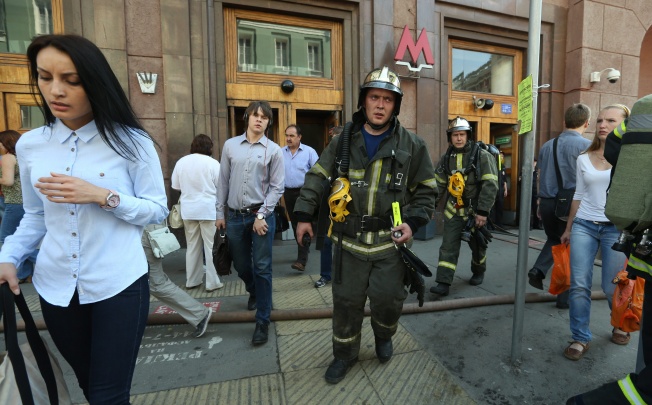 Passengers and fire fighters leave the metro station Okhotny Riad in the center of Moscow. Photo: EPA