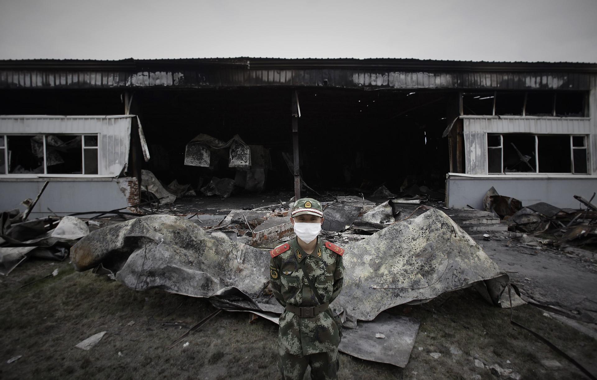 A paramilitary policeman guards the burnt-out plant. Photo: Reuters