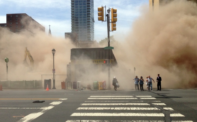 A dust cloud rises as people run from the scene of a building collapse on the edge of Philadelphia. Photo: AP