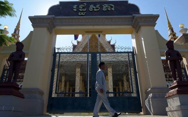 A Cambodian guard walks past the main gate of the National Assembly building in Phnom Penh. Photo: AFP