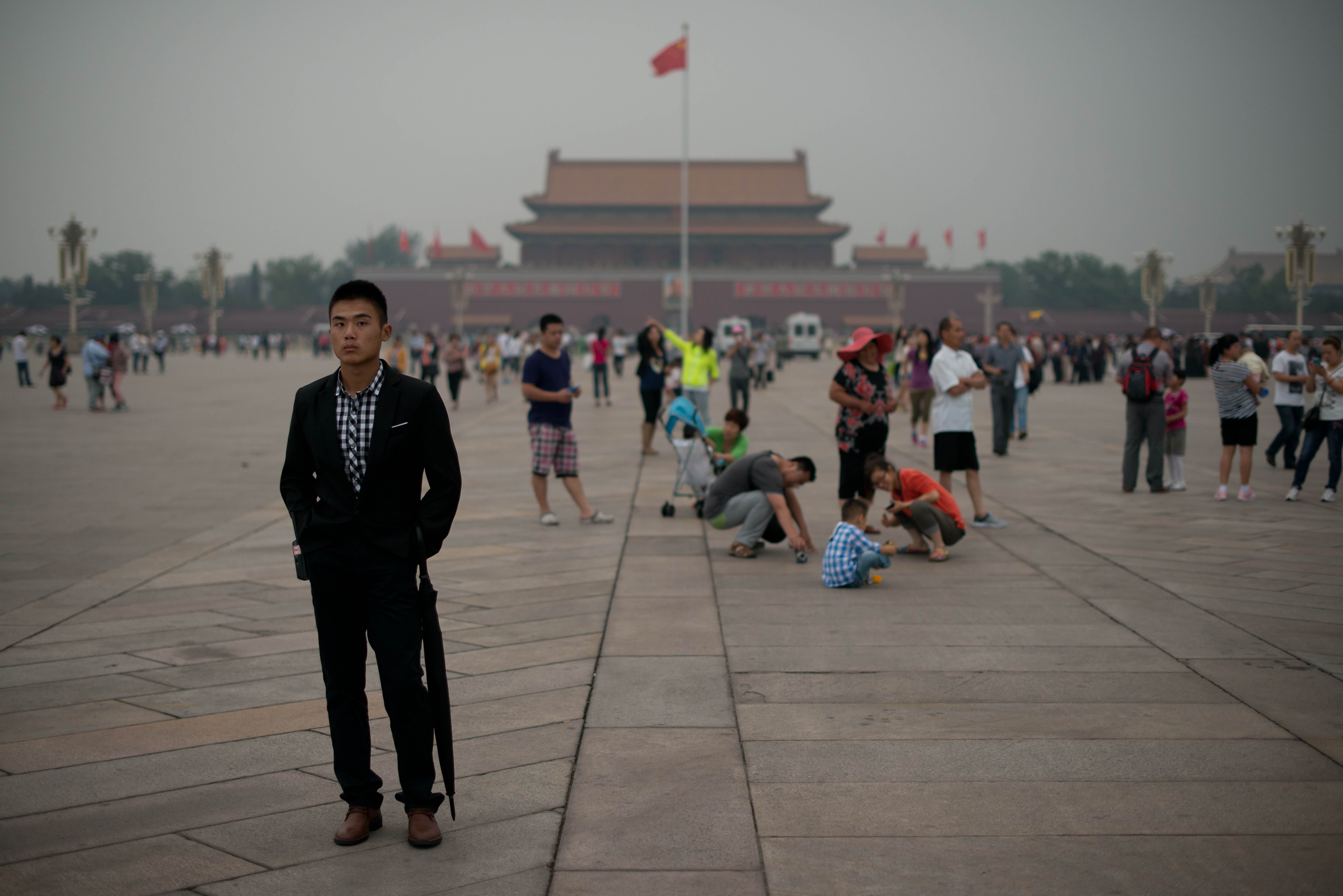 A plain-clothes policeman (left) follows suspected journalists on Tiananmen Square in Beijing on June 4, 2013. Photo: AFP