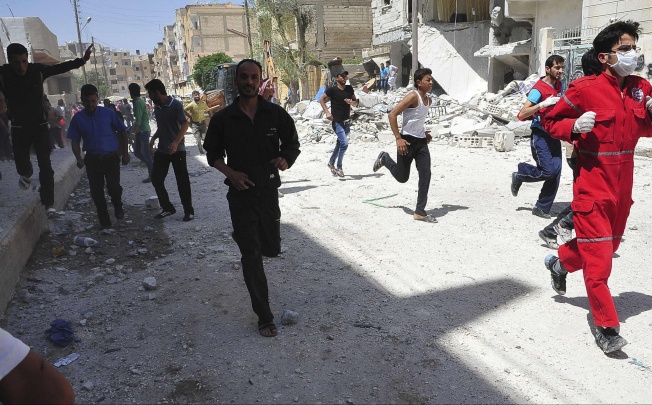 People run for cover after what activists said was shelling by forces loyal to Syria's President Bashar al-Assad in Raqqa province, eastern Syria. Photo: Reuters
