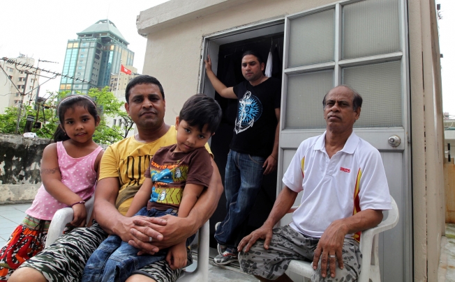 For Habibur Rahman (in yellow) and his children, John (in black), and Mohamed Sultan (in white), falling ill here will leave them reeling from their medical bills. Photo: May Tse