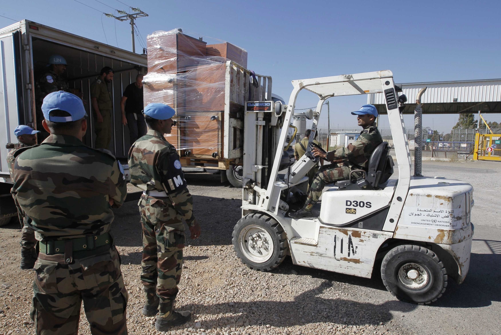 UN peacekeeping soldiers load a truck with furniture removed from the offices of Austrian UN troopsin the Golan Heights. Austrian UN troops have begun leving the Golan Heights. Photo: Reuters