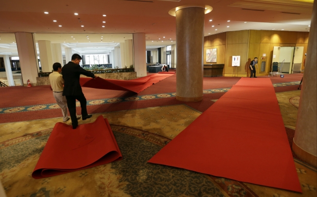 Workers roll up red carpets to remove them from the venue for the Koreas' first high-level meeting at Grand Hilton Hotel in Seoul. Photo: AP