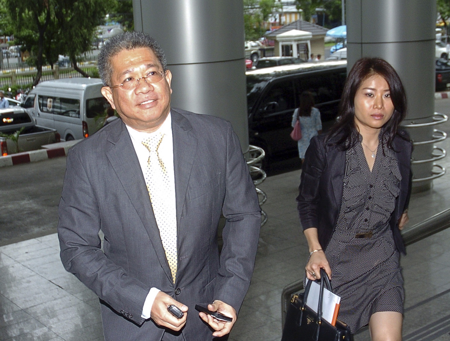 Akeyuth Anchanbutr  (left) walks with an unidentified aide at criminal court in Bangkok, Thailand. Photo: AP