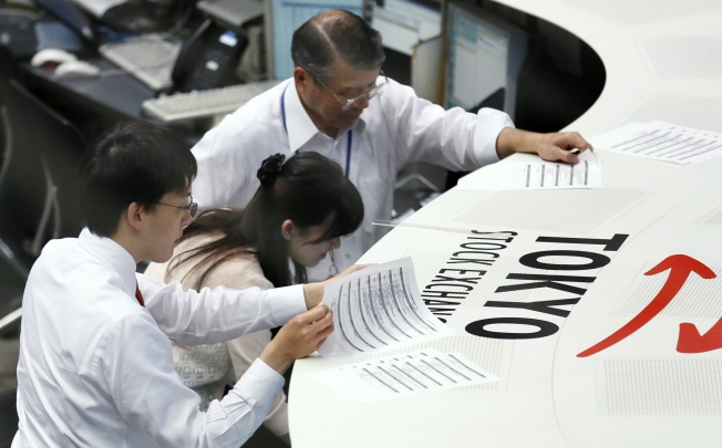 Tokyo Stock Exchange staff check activities of stock trade after closing the afternoon trading session at the TSE in Tokyo, Japan. Photo: EPA