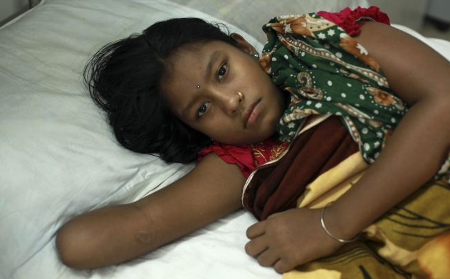 A woman, who lost her arm in the Rana Plaza building collapse, undergoes treatment at a Bangladesh hospital. The April 24 building collapse caused 1,130 deaths. Photo: EPA