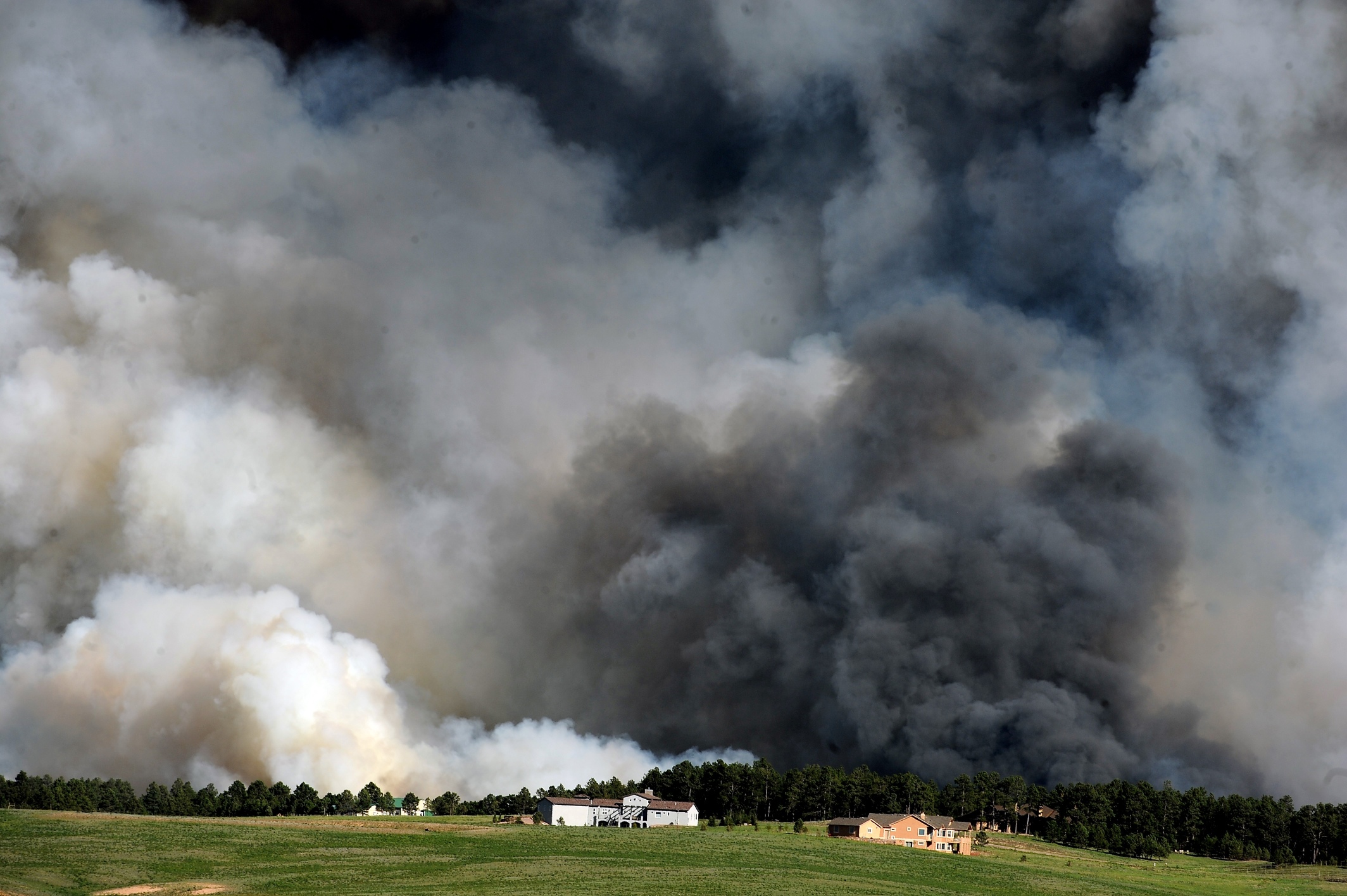 Large plumes of smoke rise from a wild land fire in the Black Forest northeast of Colorado Springs.  Two people have been killed by the fires. Photo: AP