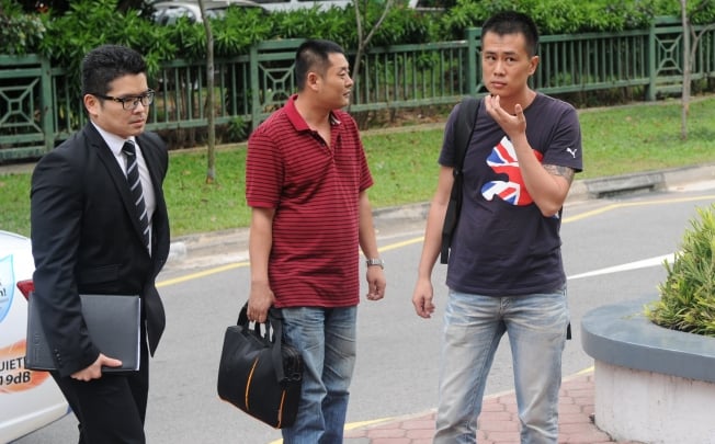 Liu Xiangying (C) and Gao Yue Qiang (R), two of the four Chinese drivers who instigated an illegal strike last November arrive at the subordinate court in Singapore on February. Photo: AFP