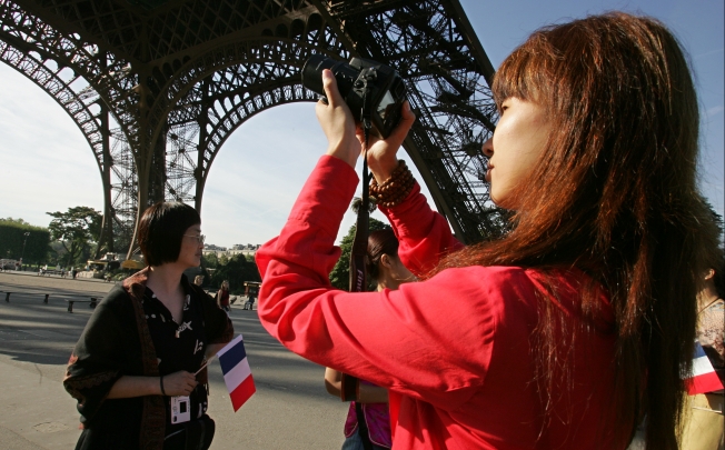 Chinese tourists visit the Eiffel Tower in Paris. Photo: AFP