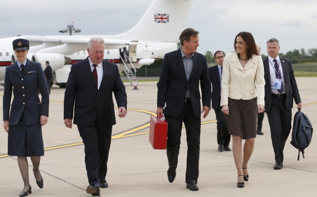 Britain's Prime Minister David Cameron walks with Northern Ireland Secretary Theresa Villiers. Photo: AP