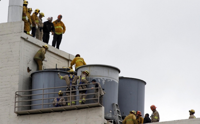The body of Elisa Lam is removed from a tank on the roof. Photo: Reuters