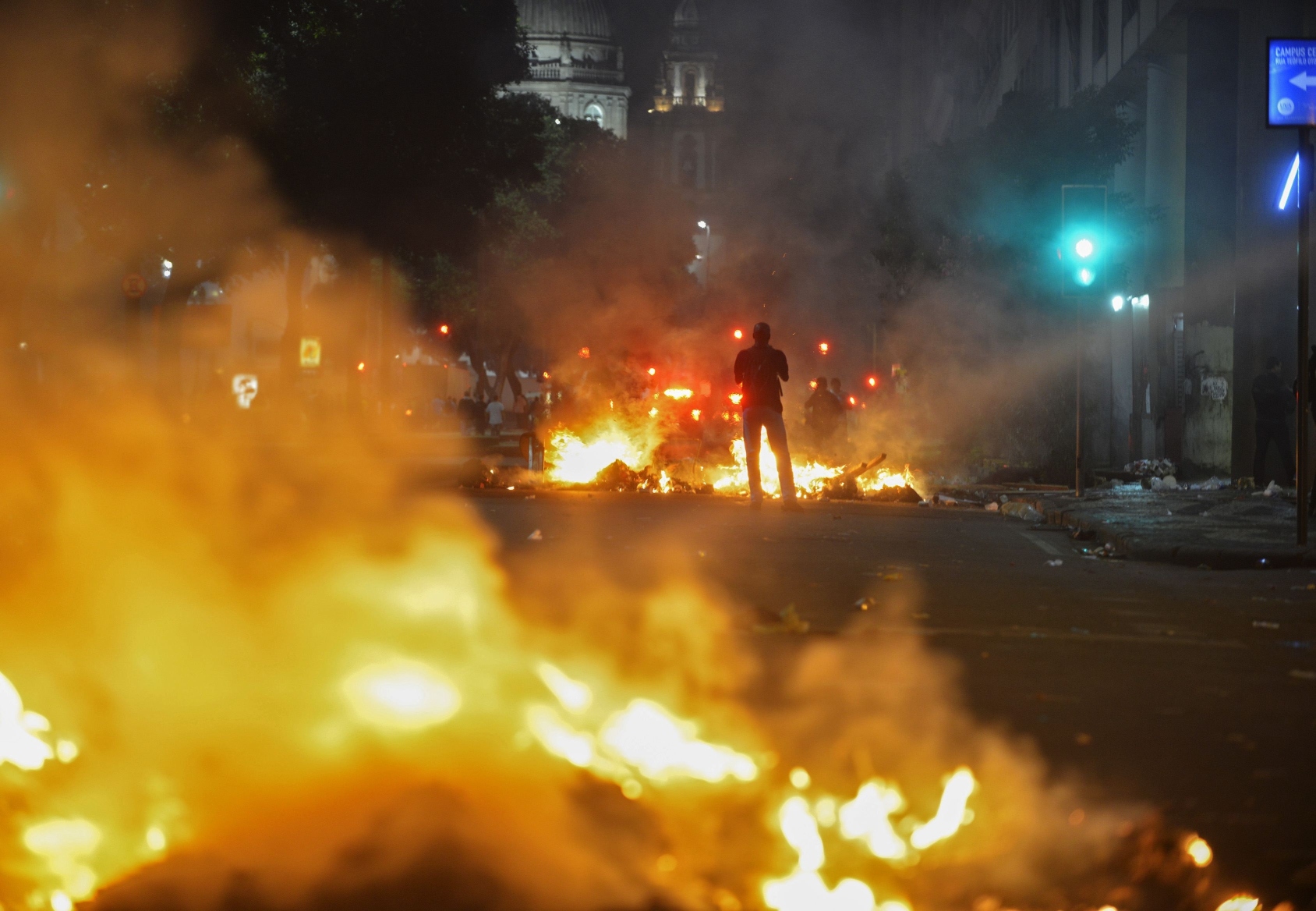 A man stands between bonfires lit by demonstrators as they clashed with police during an anti-government protest in Rio de Janeiro on Thursday. Photo: Reuters