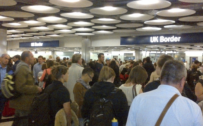 Travellers queue to be processed by UK Border Agency immigration control officers at Heathrow Airport. Photo: Reuters