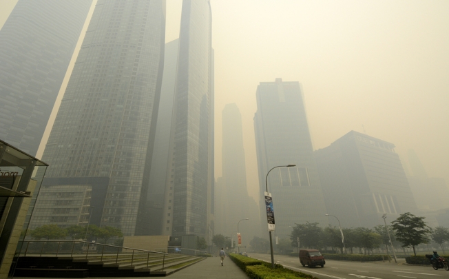 Office buildings stand shrouded in smog in Singapore. Photo: Bloomberg