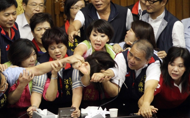 Legislators from Taiwan's ruling Kuomintang party and opposition try to seize the parliament's podium. Photo: AFP