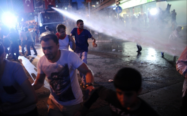 Protesters run from the jet from a water cannon on Taksim square in Istanbul. Photo: AFP