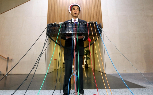 Leung Chun-ying unveils the report at government headquarters summarising his year. Photo: Sam Tsang
