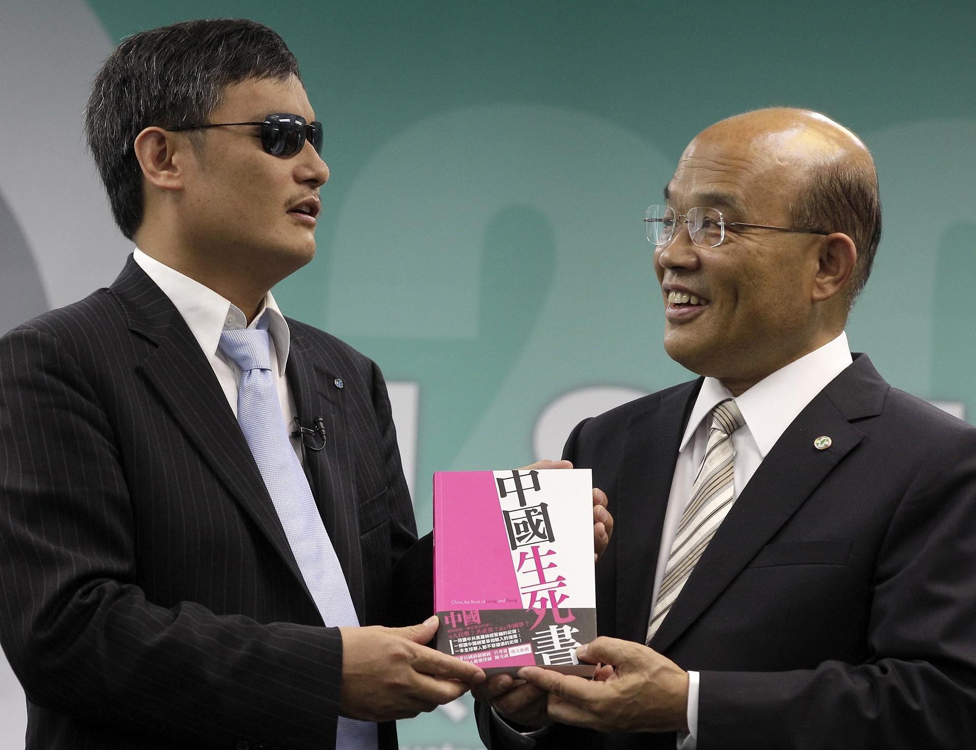 Chen Guangcheng (left) and the the DPP's Su Tseng-chang hold a new book by activists, China, the Book of Living and Dying. Photo: Reuters
