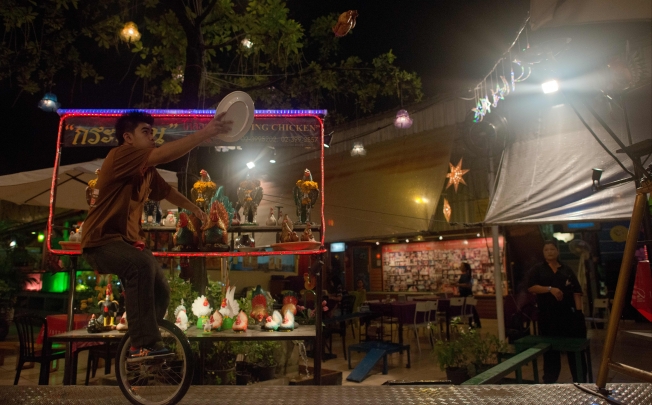 A waiter on a unicycle catching a flying chicken sent by a catapult at the Ka Tron restaurant in Bangkok. Photo: AFP