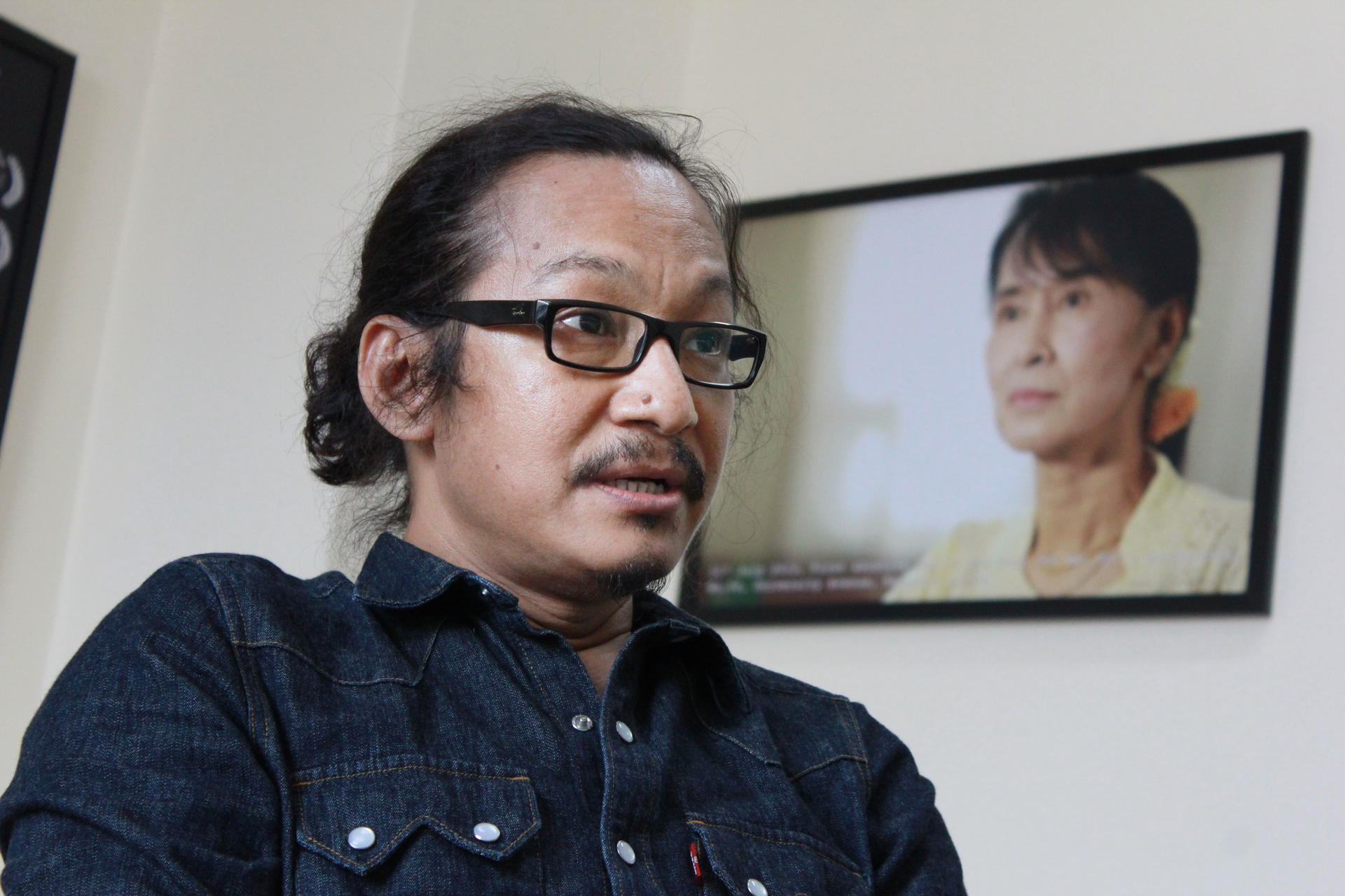 Myanmese filmmaker Min Htin Ko Ko Gyi, with a photograph of his inspiration, Aung San Suu Kyi, in the background. Photo: Hong Sar