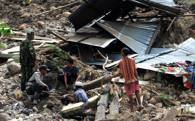 Rescuers search for missing people in the debris of houses at Serempah village in Central Aceh, Indonesia after Tuesday's earthquake. Photo: Xinhua