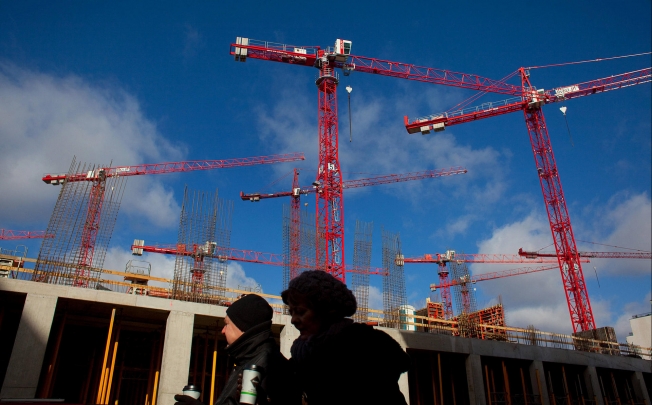 Pedestrians pass construction cranes in Berlin's Mitte district. Many recent Chinese buyers there are company executives or Bank of China staff, one agent says. Photo: Bloomberg