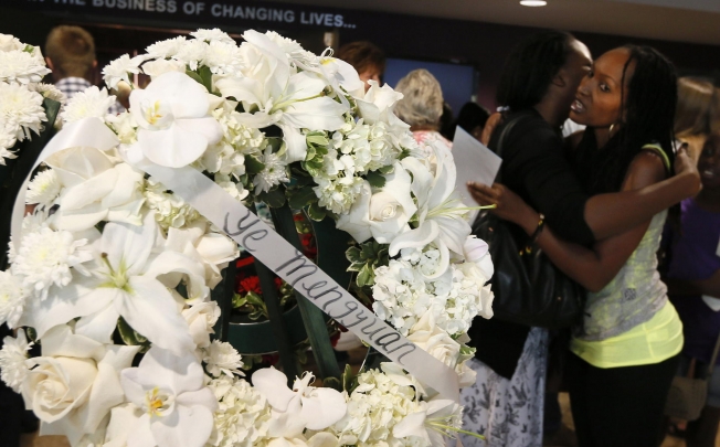 Mourners embrace near a wreath carrying the name of Ye Mengyuan at the West Valley Christian service. Photo: Reuters
