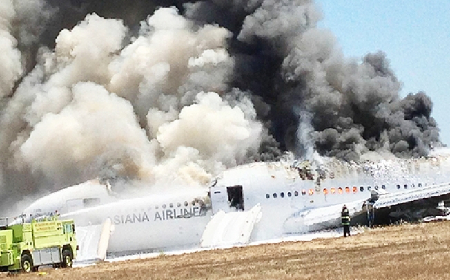 The Asiana Airlines Boeing 777 engulfed in smoke sits on the tarmac after crash landing at San Francisco International Airport. Photo: Reuters