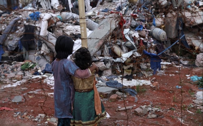 Two children look at the rubble after the Rana Plaza building collapse in Bangladesh. Photo: EPA