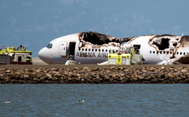 The burned Boeing 777, operated by Asiana Airlines, sits on the runway after it crashed landed at San Francisco International Airport. Photo: Bloomberg