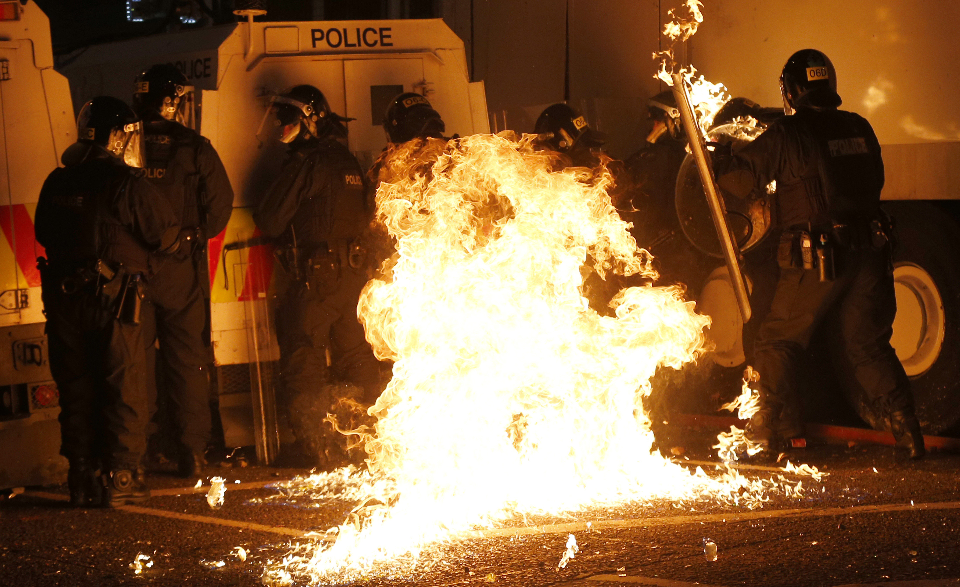 A petrol bomb thrown by loyalist rioters hits a group of riot policemen in the Woodvale area of north Belfast, Northern Ireland. Photo: AP
