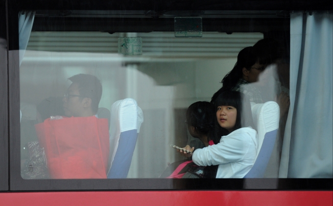 Students and teachers of Jiangshan Middle School are seen on a bus at Capital International Airport in Beijing as they returned to China on Saturday. Photo: Xinhua