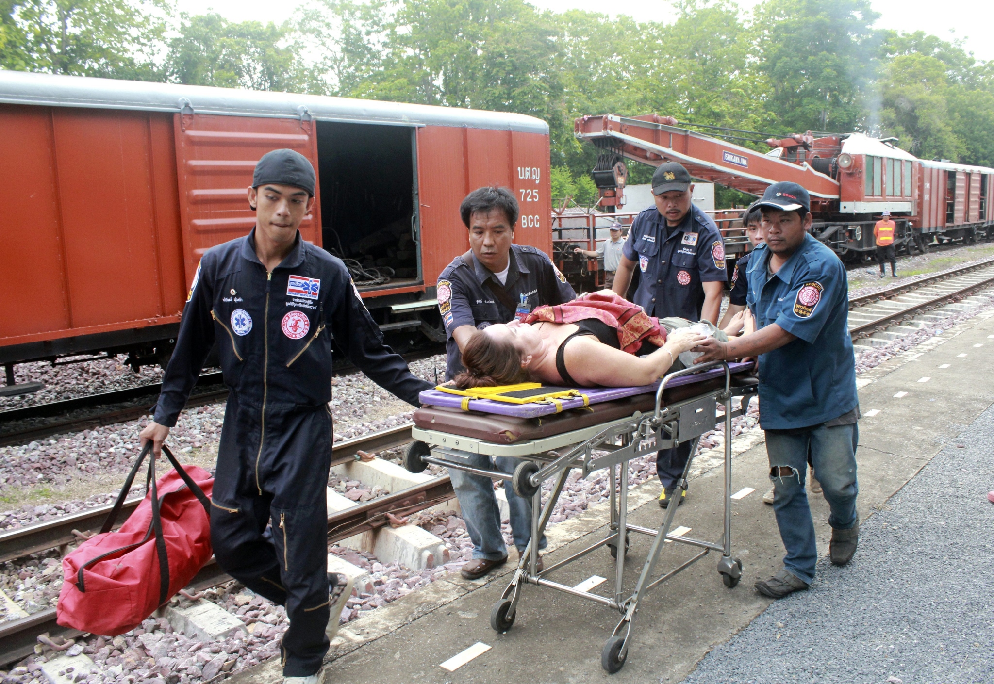 Thai rescue workers give medical treatment to an injured foreign tourist at a railway after a passenger train derailed in Den Chai district of Phrae province in northern Thailand. Photo: EPA