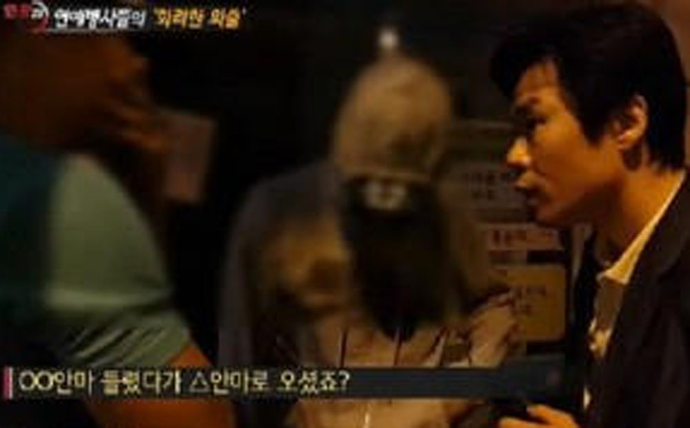 A reporter confronts singers Seven and Sangchu in a scene from the SBS video of eight celebrity soldiers caught visiting bars and clubs. 