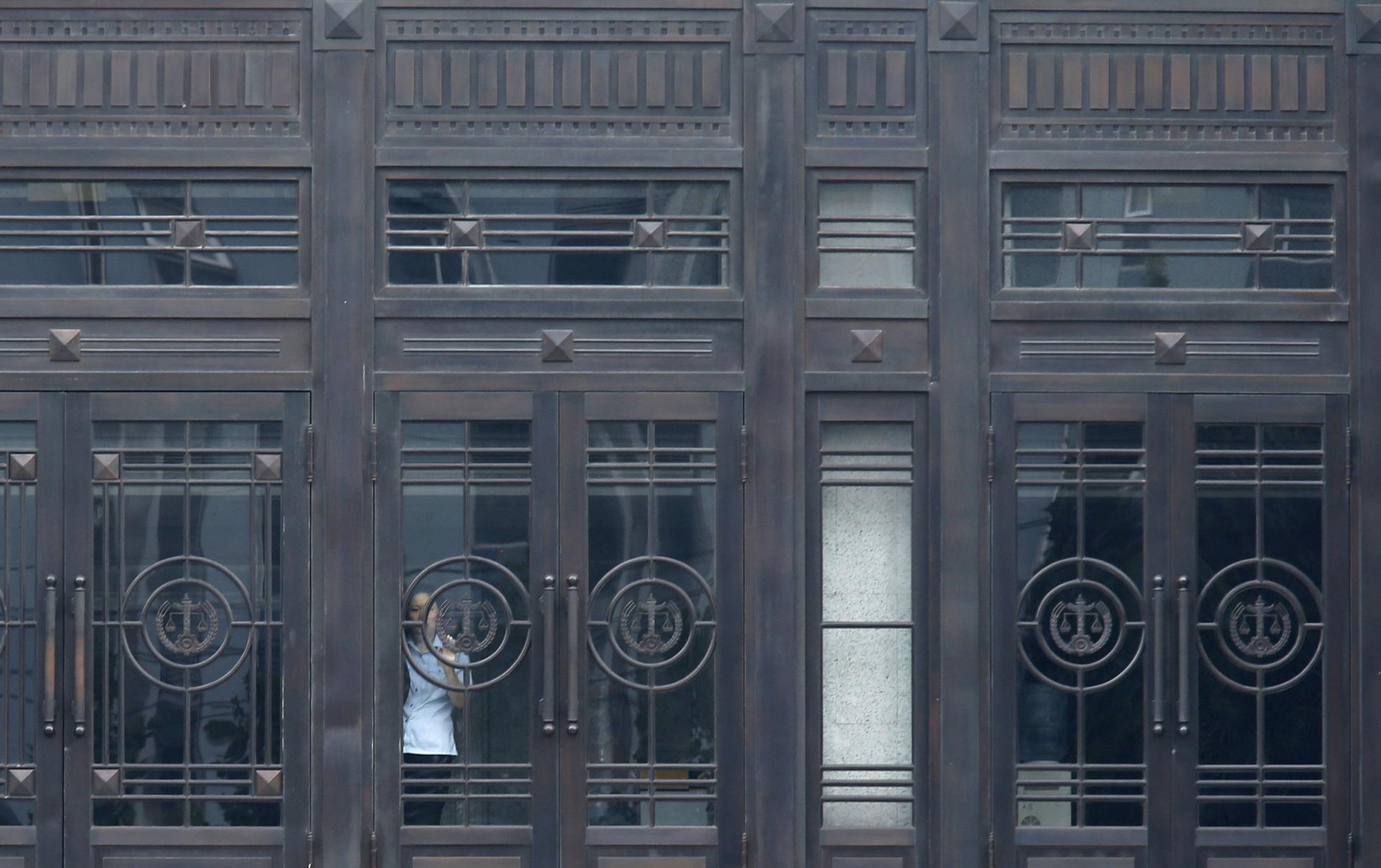 A policeman is seen through a door at the Jinan Municipal People's Intermediate Court building, where Bo Xilai will be tried. Photo: Reuters