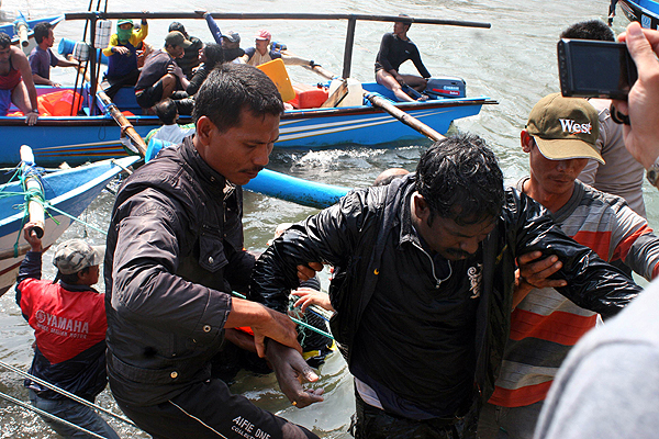 Rescuers help survivor back to land in Cidaun, West Java. Photo: AFP