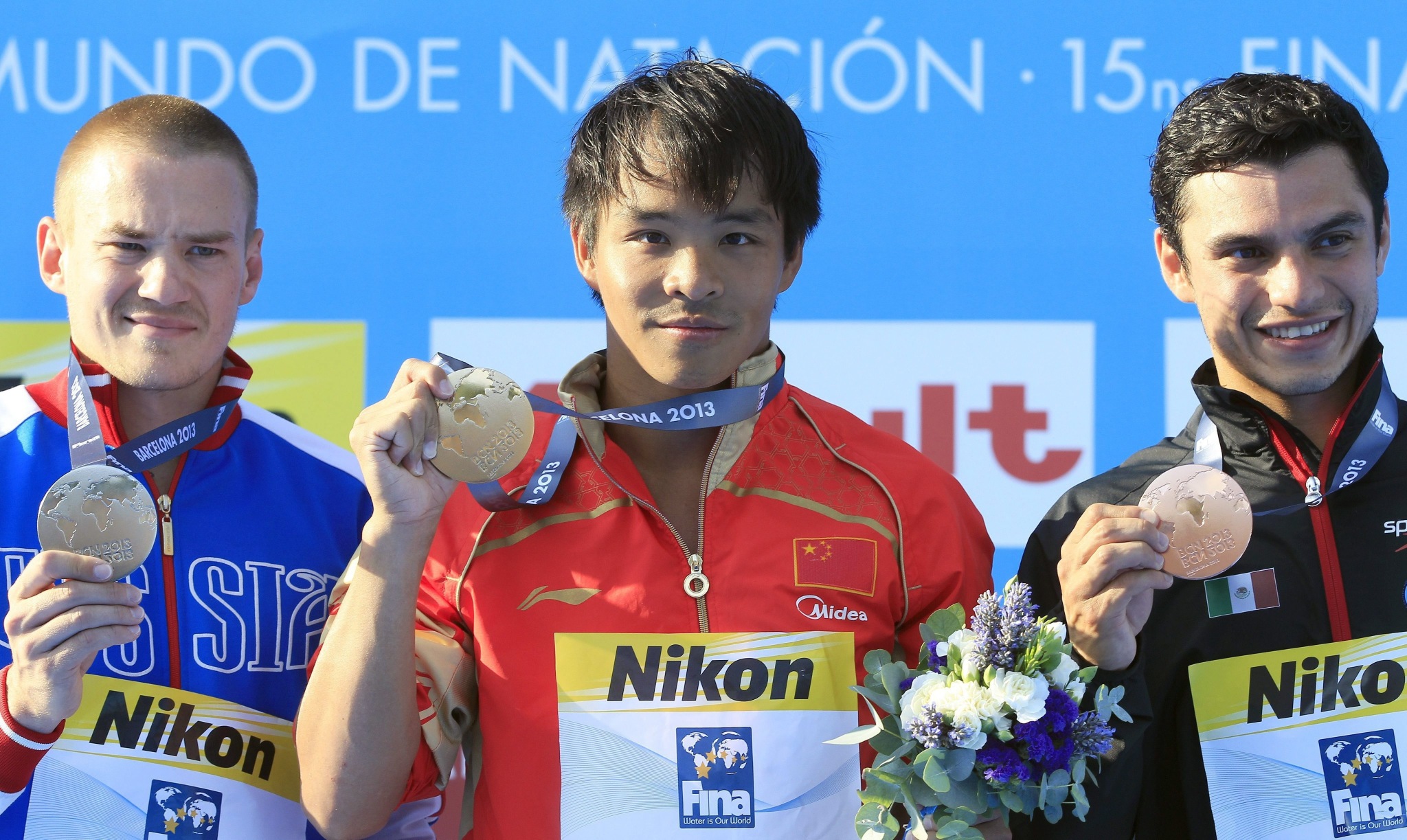 Silver medalist Russian diver Evgeny Kuznetsov (left), gold medalist Chinese Chong He (centre) and bronze winner Mexican Yahel Castillo (right) on the podium after the men's 3-metre springboard diving final of the 15th FINA Swimming World on on Friday. Photo: EPA