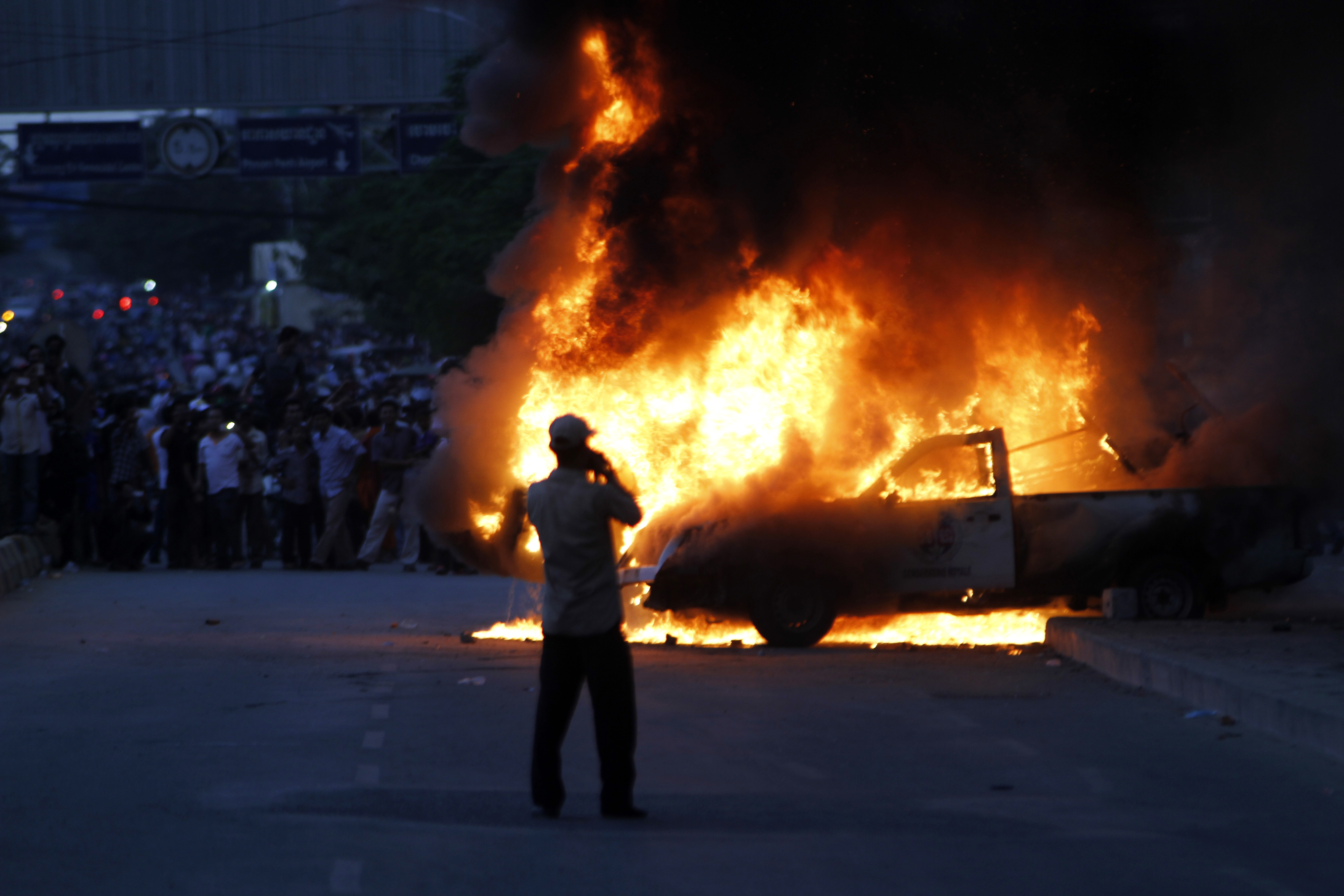 Protestors set fire on a police vehicle on Election Day in Phnom Penh. Photo: Xinhua